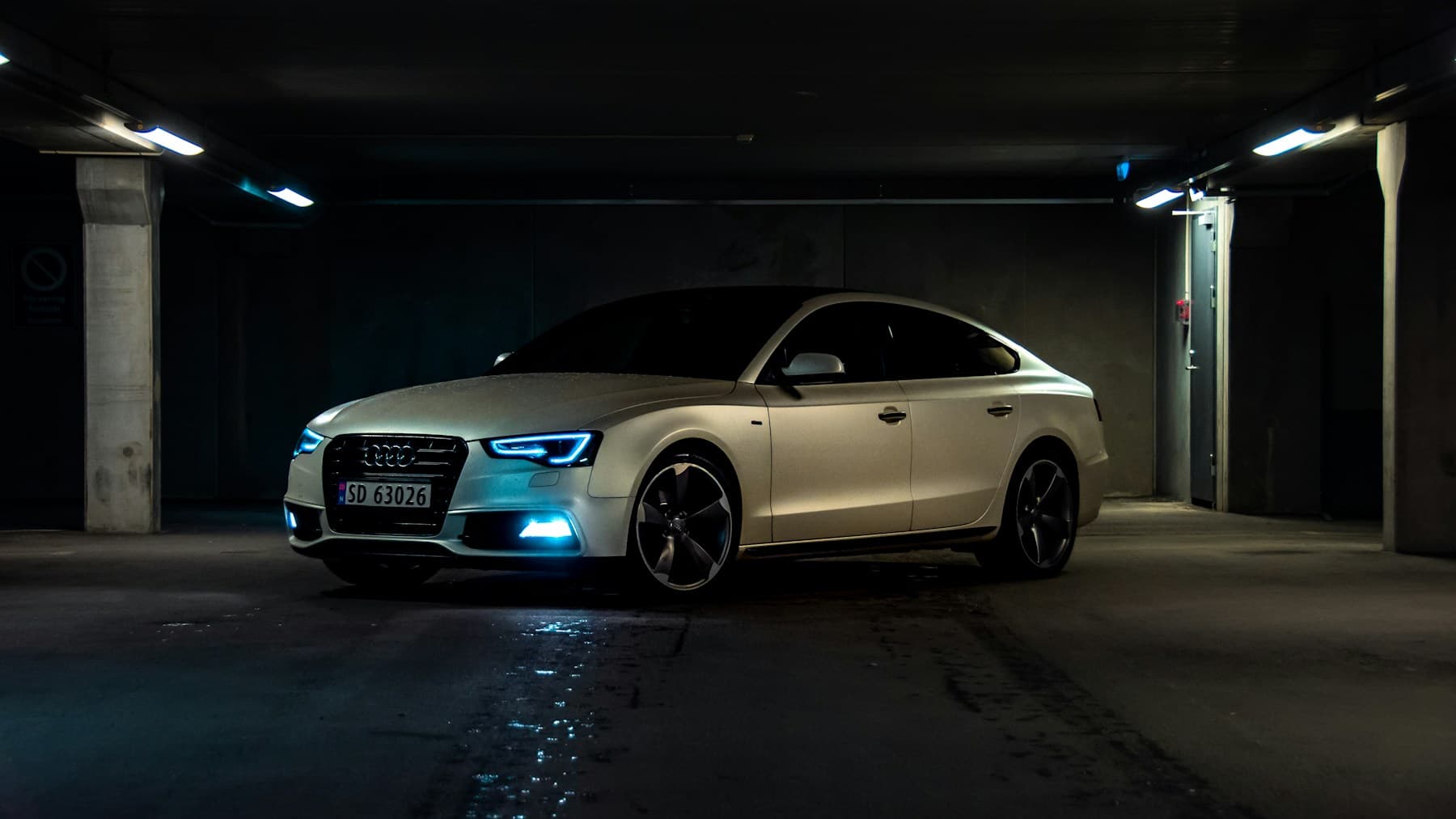 Sculpted automotive bodywork detail and reflective curves in dramatic lighting